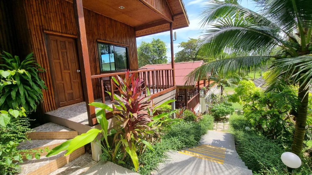 苏梅岛PawPaw Resort的一座带木门和一些植物的房子