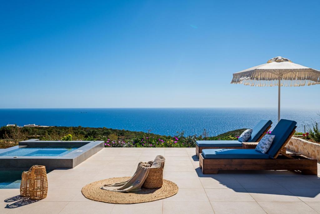 Agios LeonTerra Lucis Mountain Residences的一个带椅子和遮阳伞的庭院和一个游泳池