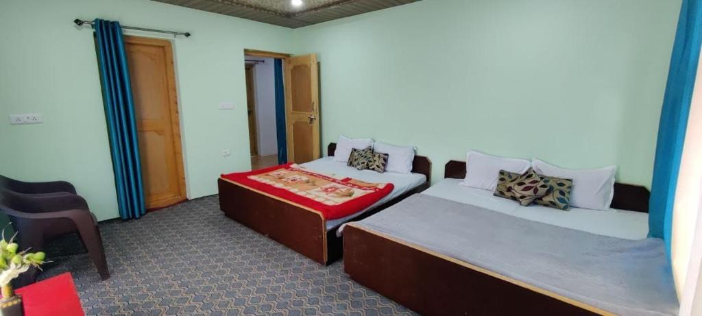 列城Nakpo Homestay的一间设有两张床和椅子的房间