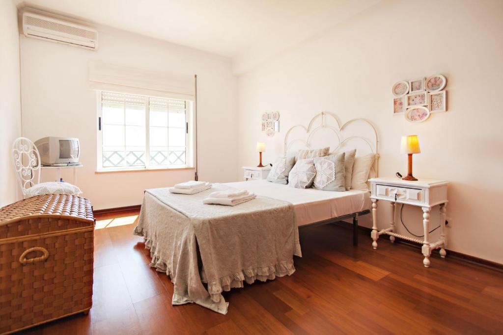 法鲁Apartamento Maresia的白色的卧室设有一张大床和一个窗户