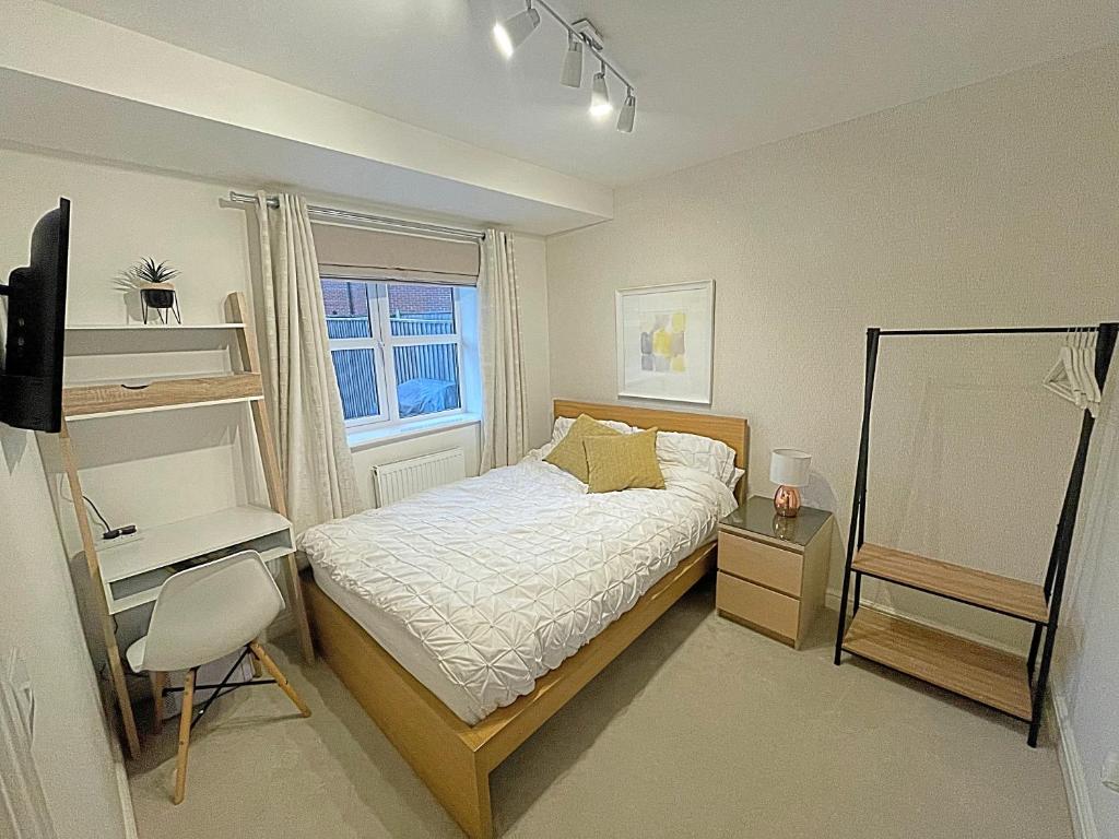 拉夫堡Cosy & Chic in great location near Loughborough Uni & East Midlands Airport的一间卧室配有一张床、一张书桌和一个窗户。