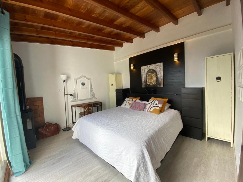 Tajace de AbajoLa Cuadra de Pascuala的卧室设有白色大床和木制天花板。