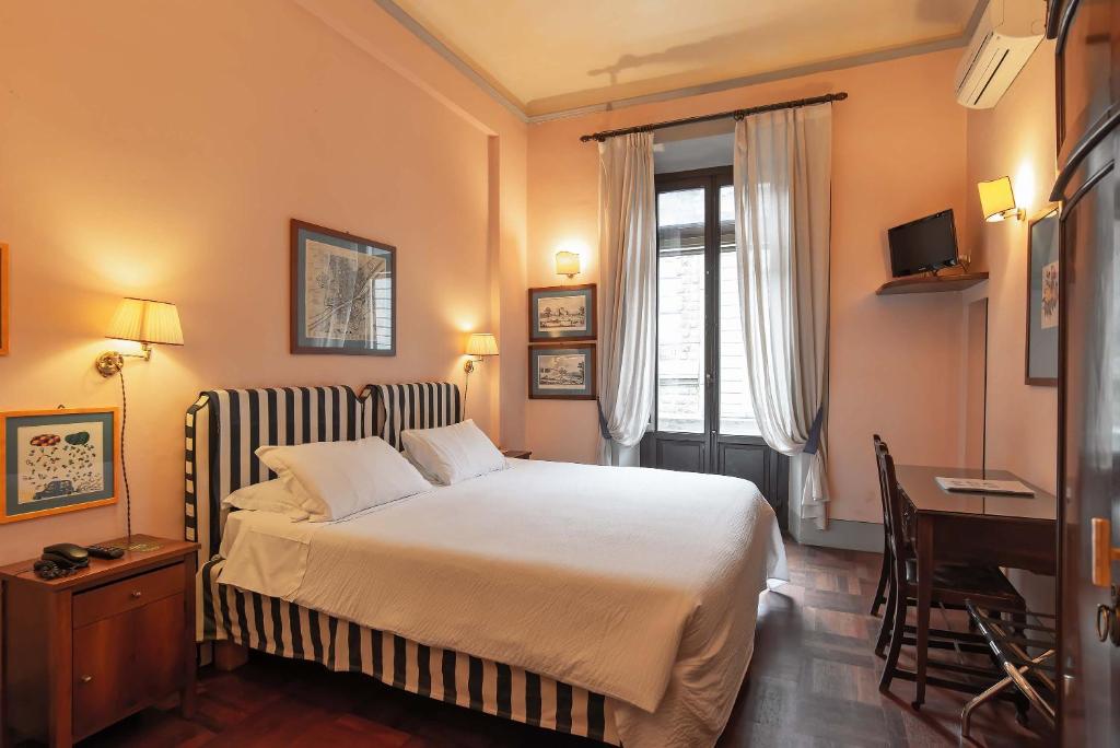 佛罗伦萨约翰娜一世住宿酒店的一间卧室配有一张床、一张书桌和一个窗户。