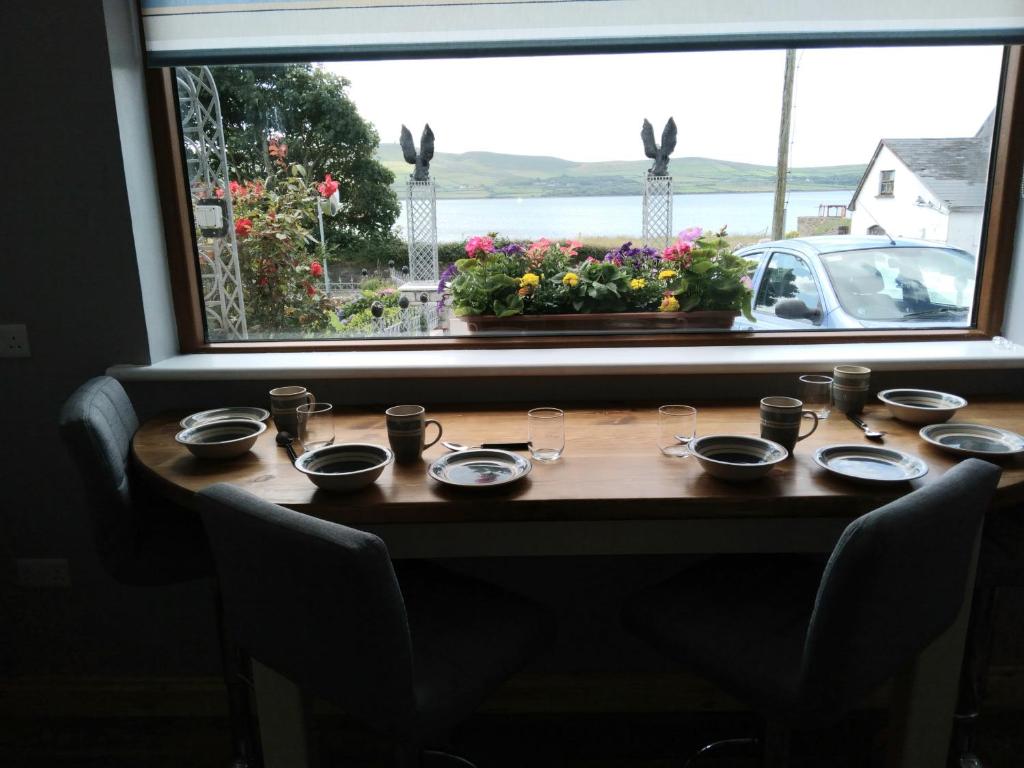丁格尔The Dingle Galley的窗前的桌子,上面有盘子和玻璃杯