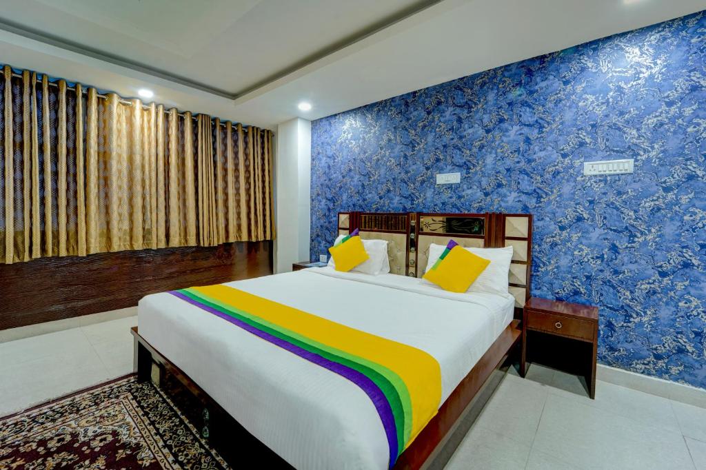 巴特那Itsy By Treebo - Buddha Inn的一间卧室设有一张大床和色彩缤纷的墙壁