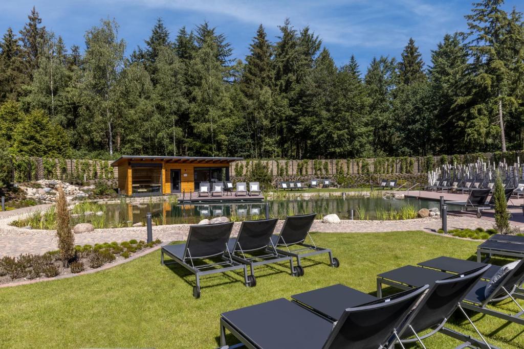 皮得斯费尔德黑德加鲁德酒店的后院设有椅子、池塘和小屋