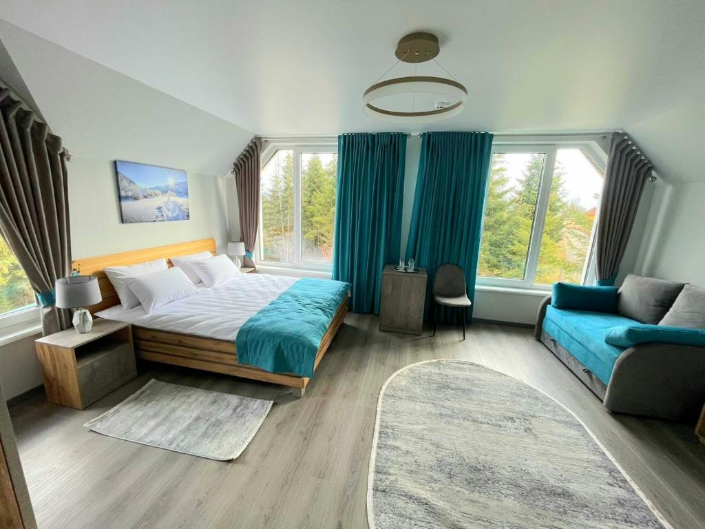 亚布卢尼齐亚Отель MONBLAN的一间卧室配有一张大床和一张蓝色的沙发