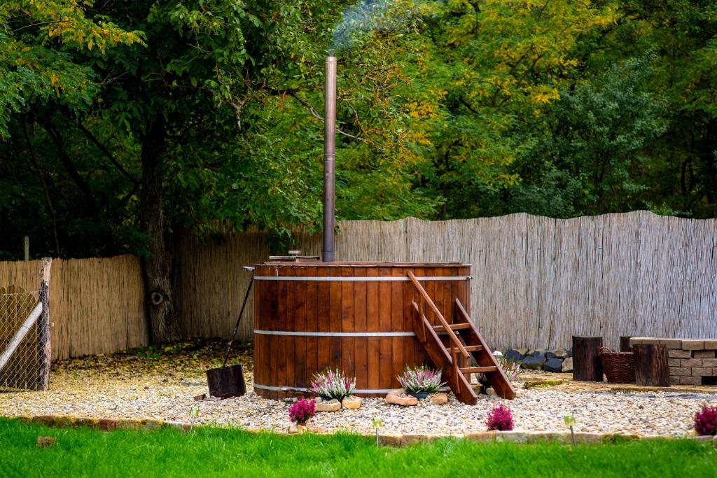 SzandaKata Cottage的围栏旁的院子内的木制热水浴缸