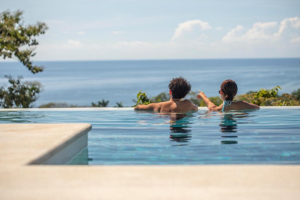蒙特苏马Adeluna Luxury Villas的游泳池里的男人和女人