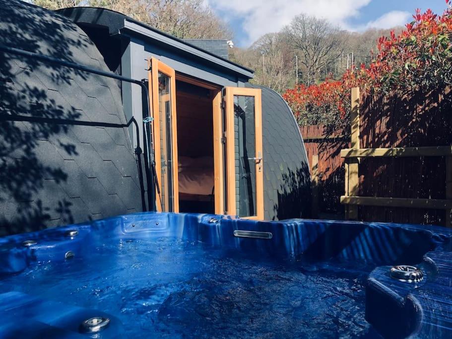 巴茅思River Side Cabin with Hot tub Snowdonia的房屋前的大蓝色浴缸