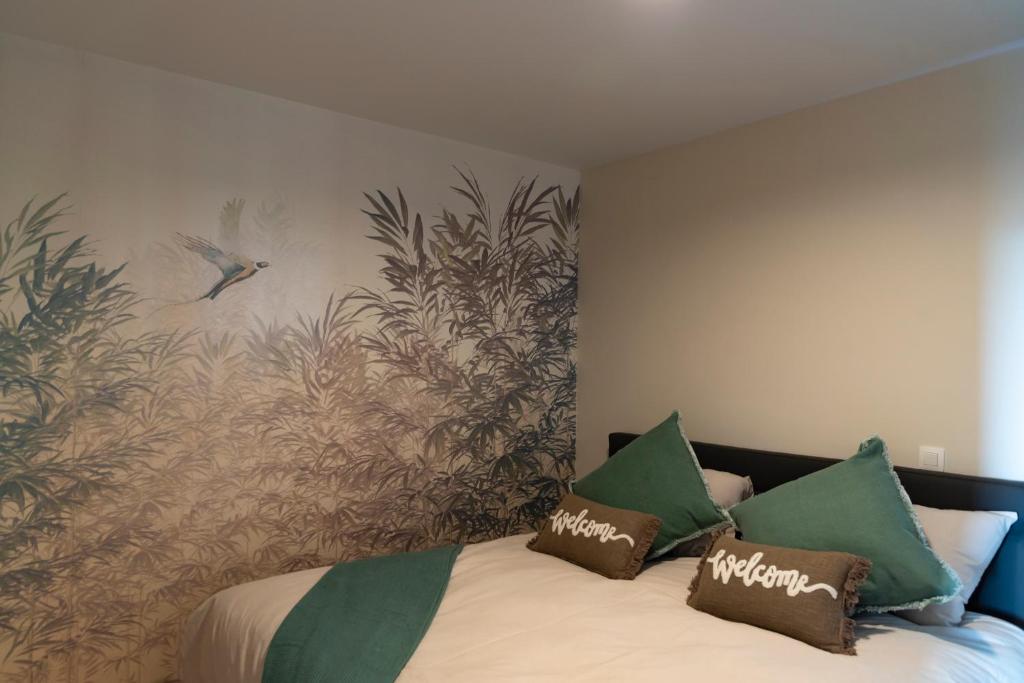 WingeneDe Weldoeninge的一间卧室配有带绿色和棕色枕头的床