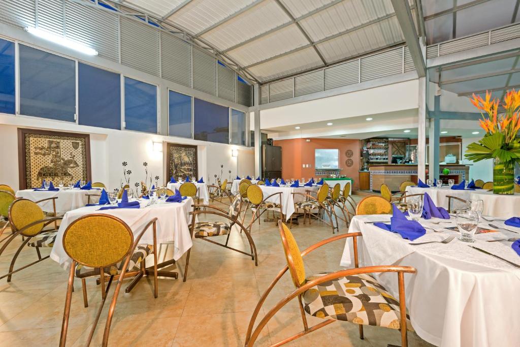 伊瓦格丹恩科姆贝玛酒店的宴会厅配有桌椅和蓝色餐巾
