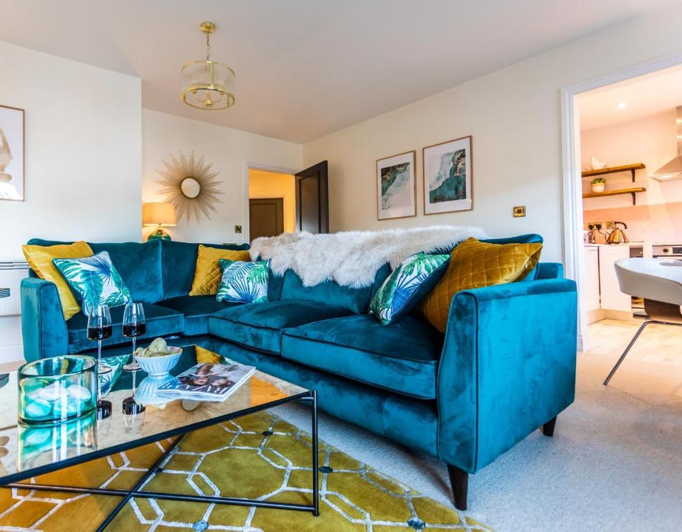 沃里克Chic, immaculate, stylish Warwick apartment close to town & castle - perfect for short & long breaks的客厅配有一张蓝色的沙发,配有一张桌子