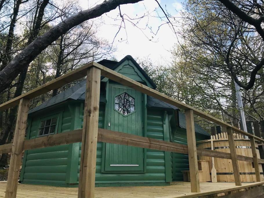 巴茅思Woodland Cabin with Hot tub & log burner的绿色小屋 - 带木栅栏