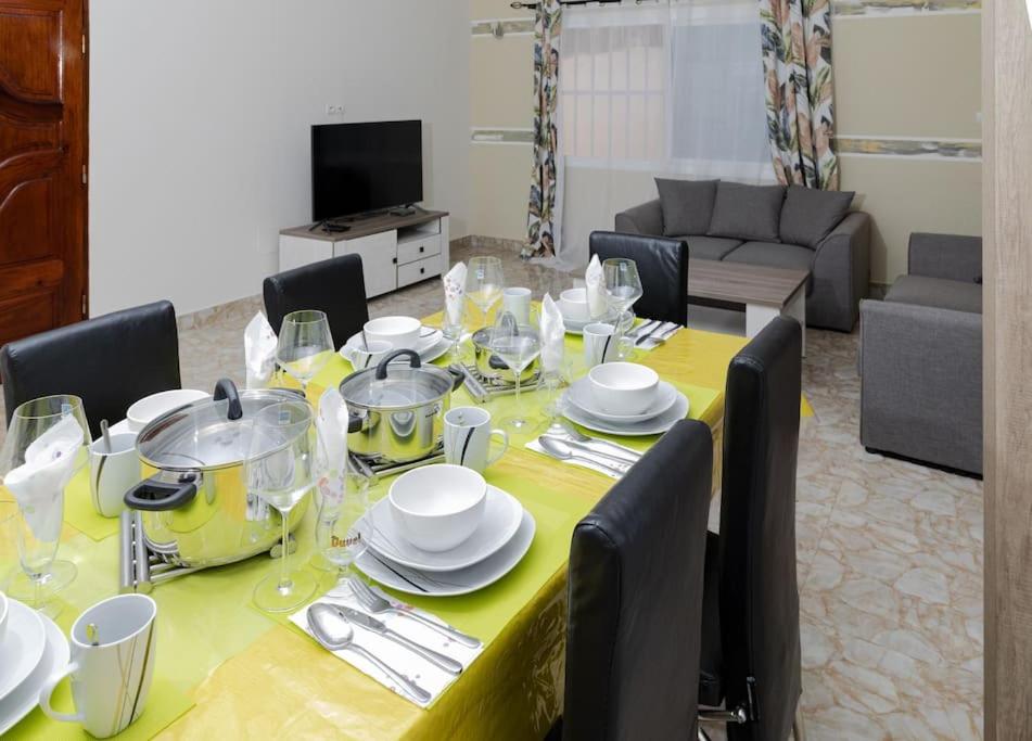 Maison Bethel Kpogan Afidenigba的餐桌、黄桌布和椅子