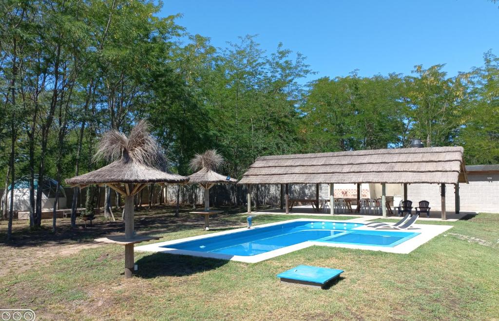 VillarsLa Yuma en Villars的一个带遮阳伞和凉亭的游泳池
