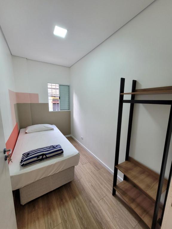 圣保罗Self Hostel的一间卧室配有一张床,铺有木地板