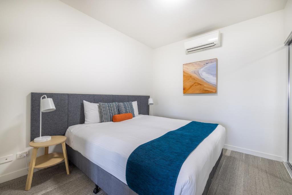 麦凯Aligned Corporate Residences Mackay的一间卧室配有一张带蓝白色毯子的床