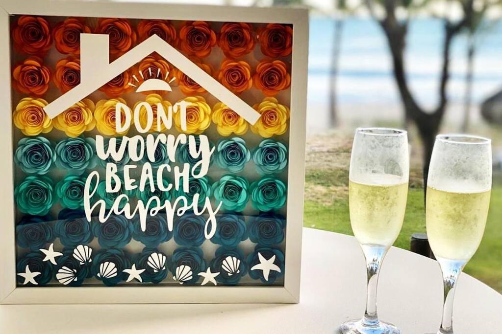 查梅Playa Caracol, beach happy的桌子上放着两杯香槟,上面有标志,上面写着“不担心海滩快乐”