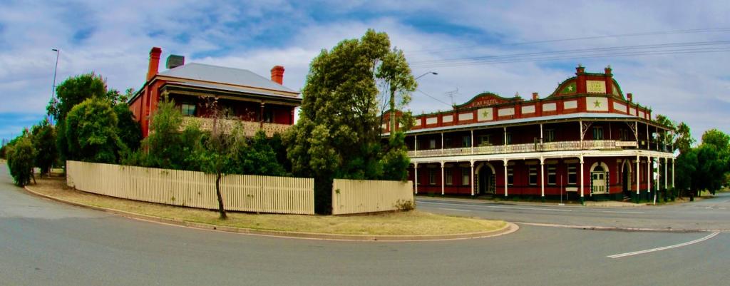 纳兰德拉HISTORIC STAR LODGE and STATION MASTERS HOUSE NARRANDERA的街道拐角处的红白色建筑