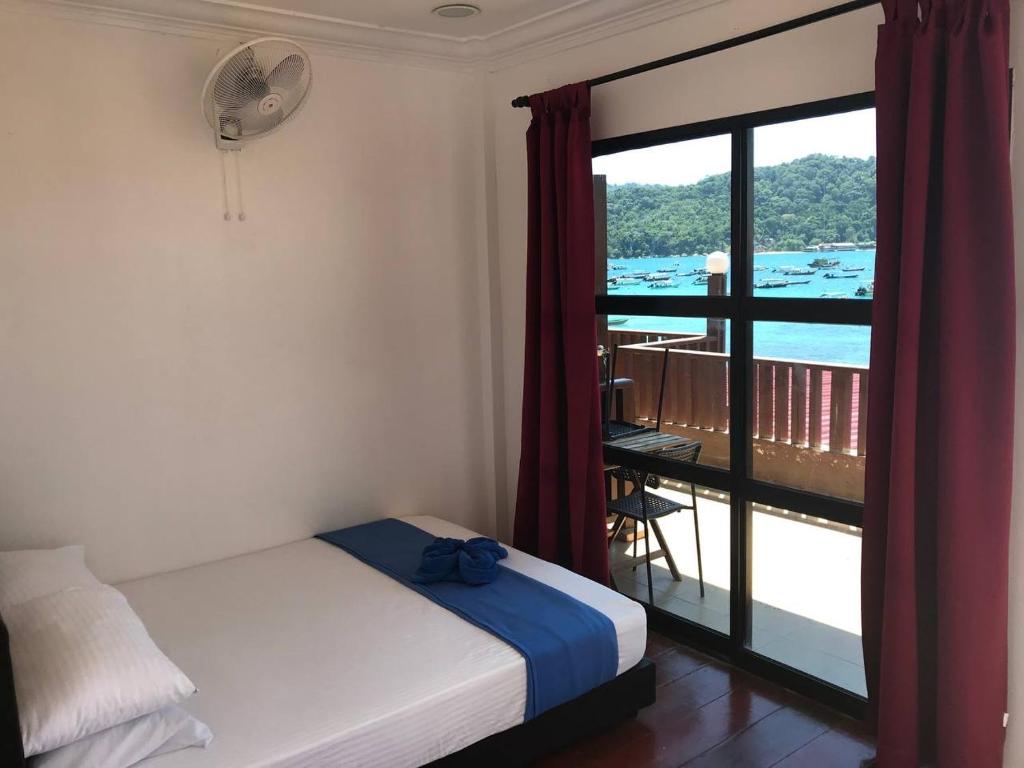 停泊岛Perhentian Nemo Chalet的一间卧室设有一张床,享有阳台的景色