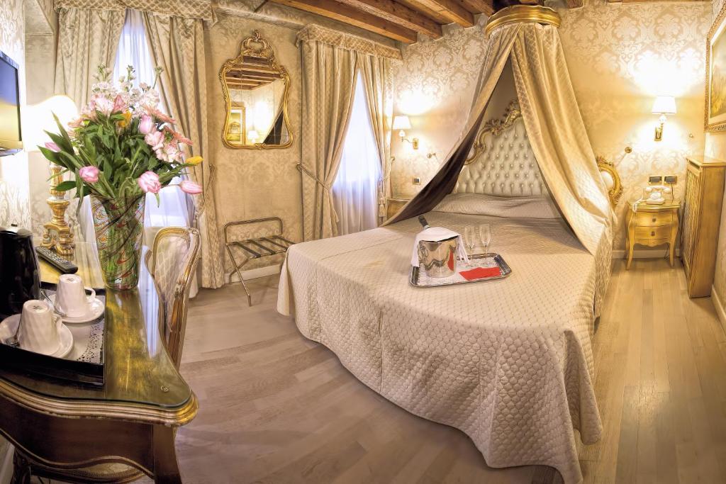 威尼斯诺埃米酒店的一间卧室,配有一张带花瓶的床