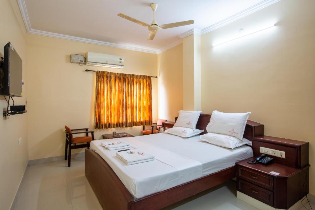 哥印拜陀Sri Aarvee Hotels的一间卧室设有一张大床和一个窗户。
