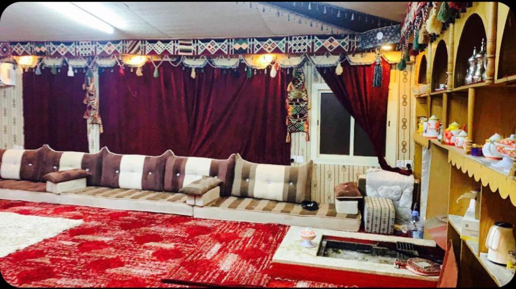Madain Salehاستراحات ومخيم يمك دروبي的带沙发和红色地毯的客厅