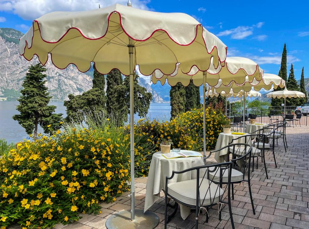 马尔切西内Hotel Oasi Beach的一间餐厅,配有桌椅,位于伞下