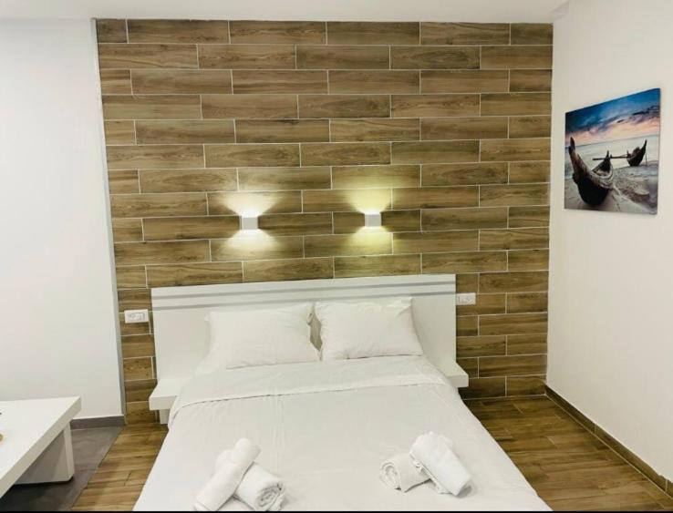 埃拉特Eilat Charming Studio-Balcony的一间卧室，有一张白色的床和一面砖墙