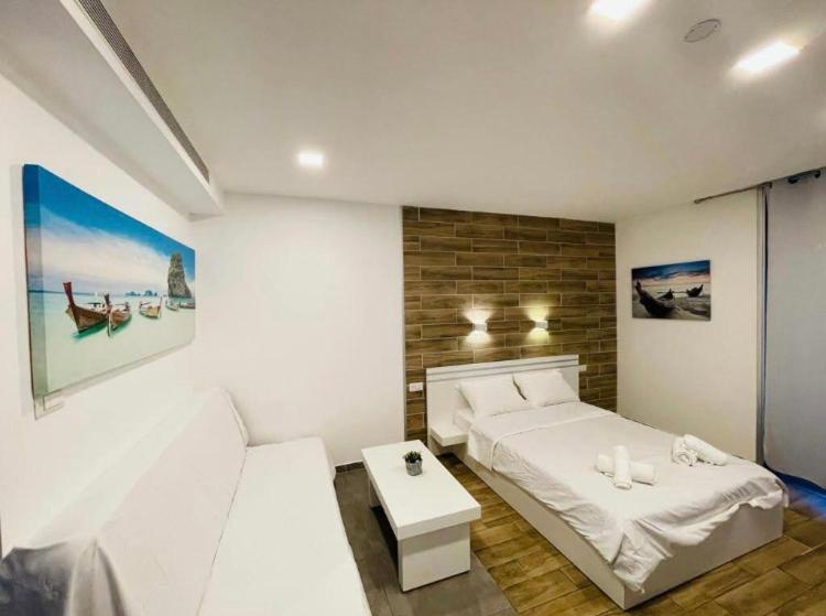 埃拉特Eilat Charming Studio-Balcony的一间带床和桌子的白色卧室