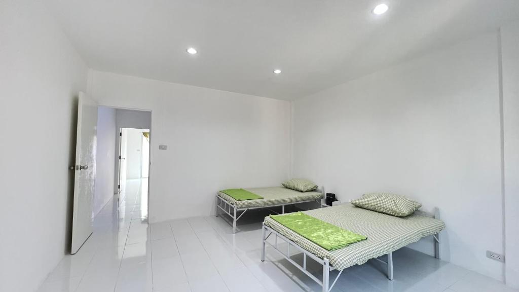 曼谷Bangkok Private 4Bedrooms-Parking-Weekly Special Offer的白色墙壁客房的两张床