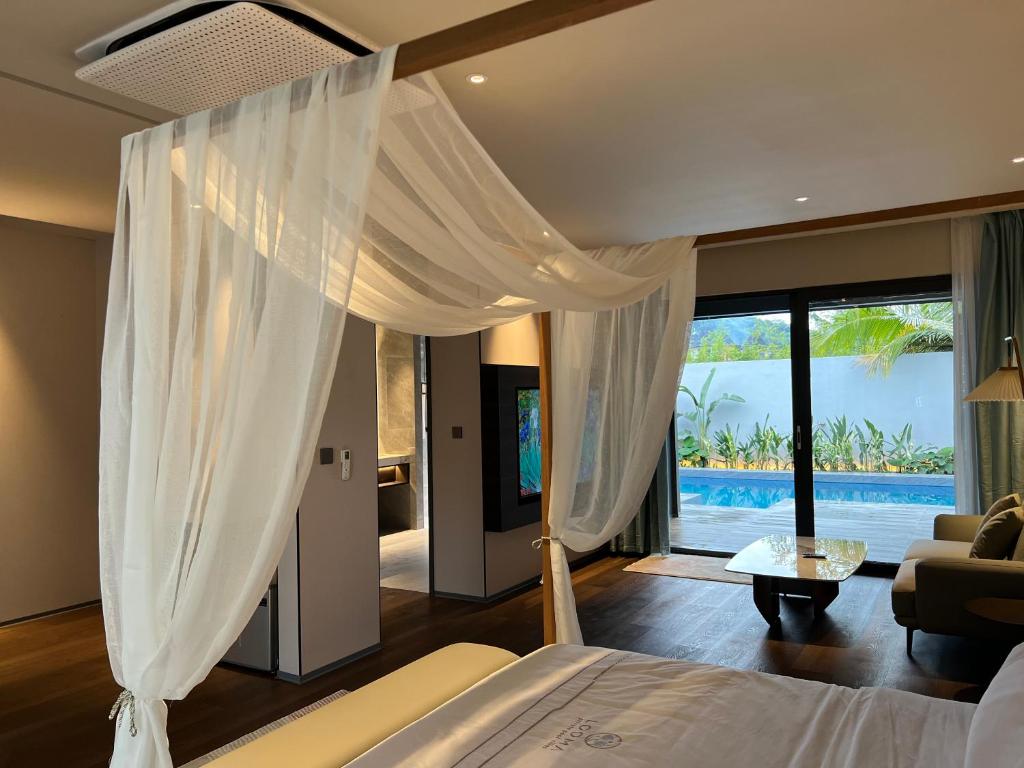 珍南海滩Looma Private Pool Villas的一间卧室配有一张床,享有游泳池的景色