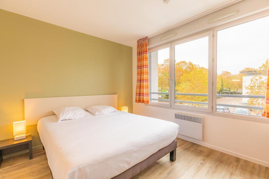 布雷斯地区布尔格Appart'City Classic Bourg-en-Bresse的一间卧室设有一张床和一个大窗户