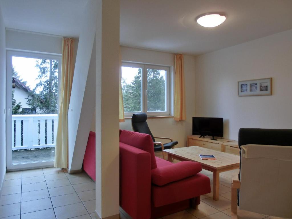 HirschburgFerienwohnung NH14的客厅配有红色椅子和电视