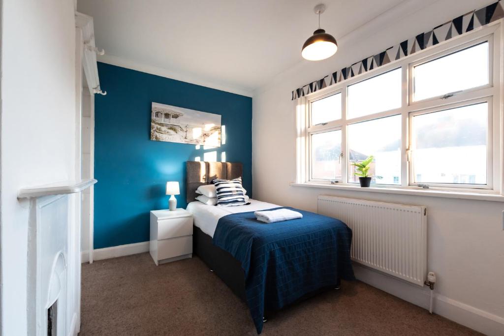 南安普敦Comfortable and convenient stay 3 bed house的一间卧室设有一张床和蓝色的墙壁