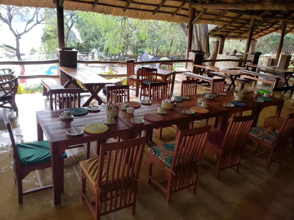 MagangaNg'ona Lodge的餐厅里一张大木桌子和椅子