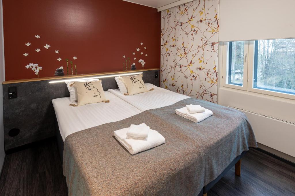 图尔库Hotel Linnasmäki的一间卧室配有两张床和白色毛巾。