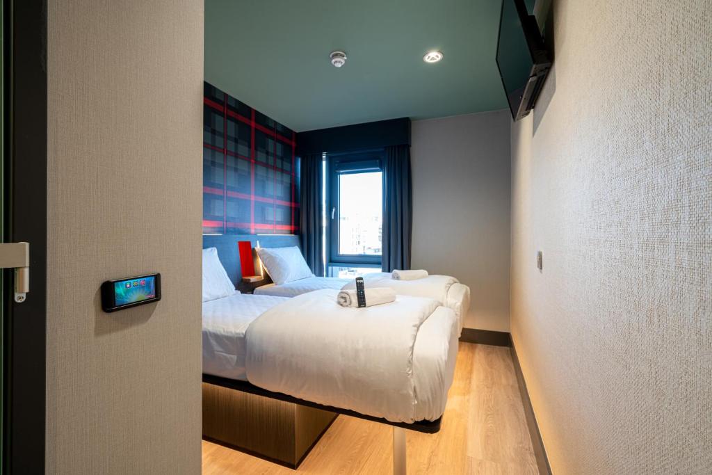 都柏林easyHotel Dublin的卧室配有白色的床和窗户。