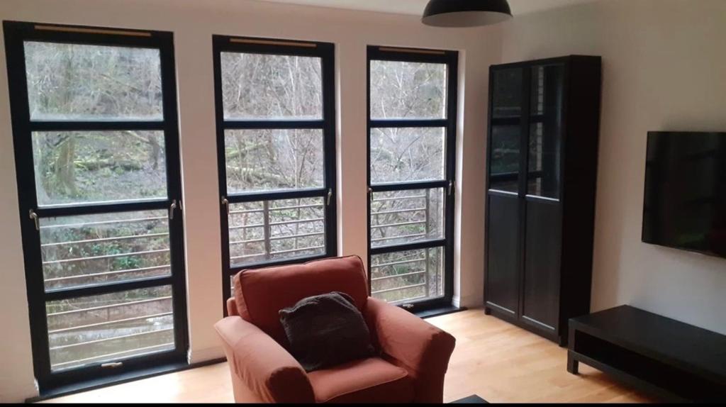 克莱德班克Duntocher village flat的客厅配有椅子和四扇窗户