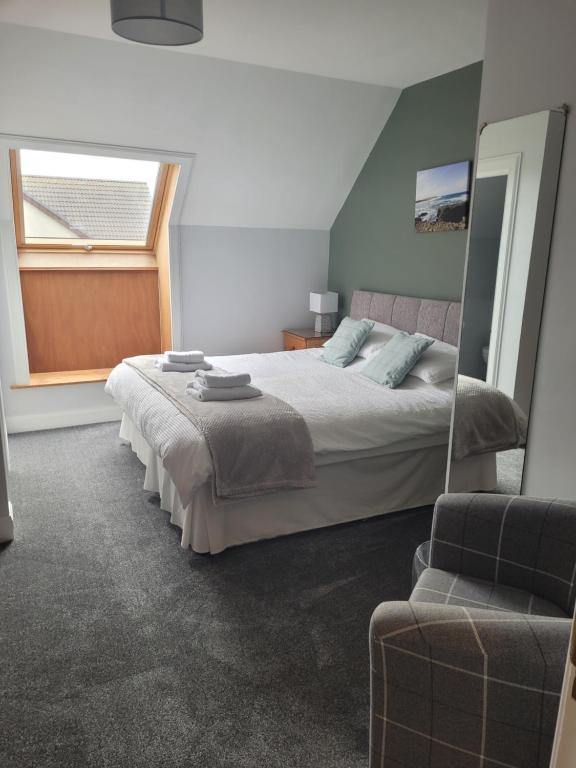 斯特罗姆内斯Lindisfarne Bed & Breakfast的一间卧室设有一张床、一个窗口和一把椅子