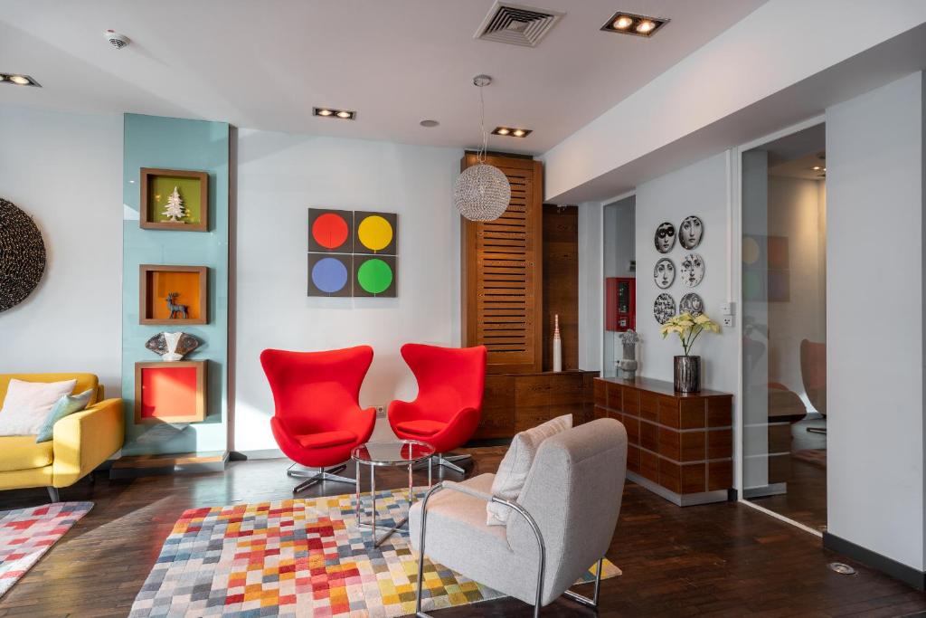 波恩numa I Bona Rooms & Apartments的客厅配有红色椅子和沙发