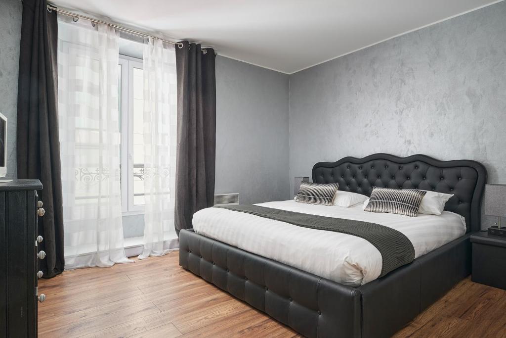 戛纳Apparthotel des Congrès et Festivals的一间卧室设有一张大床和一个大窗户