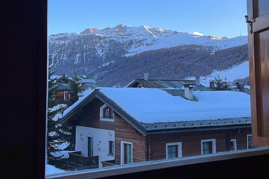 利维尼奥Appartamento Rin, Livigno的屋顶上积雪的房子的景色