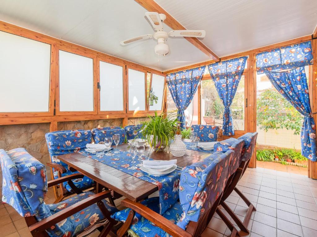 皮内达德马尔Holiday Home Aurea by Interhome的一间带桌子和蓝色椅子的用餐室