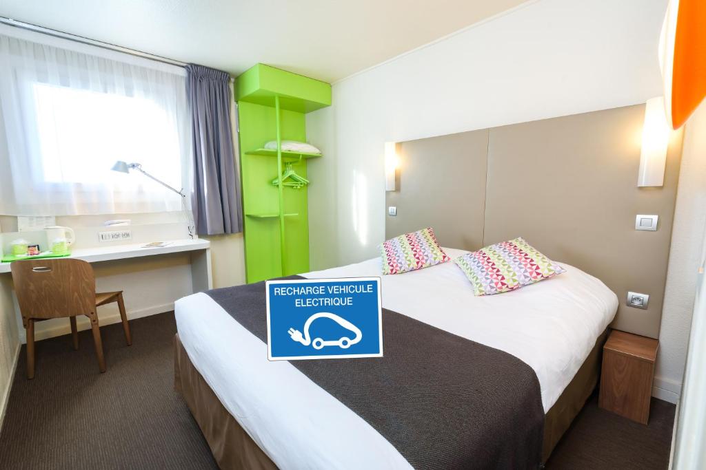 图卢兹钟楼图卢兹普尔班酒店的酒店客房,配有一张带标志的床