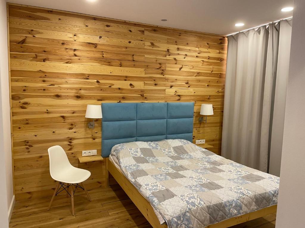 格但斯克旧城Willa BROWAR pokoje gościnne的一间卧室设有木墙、一张床和一把椅子