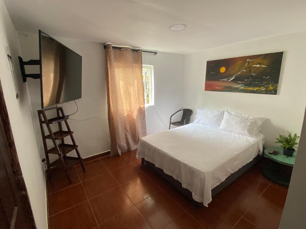 亚美尼亚MAGICA CABAÑA EN MEDIO DE LA NATURALEZA的卧室配有白色的床和墙上的绘画作品
