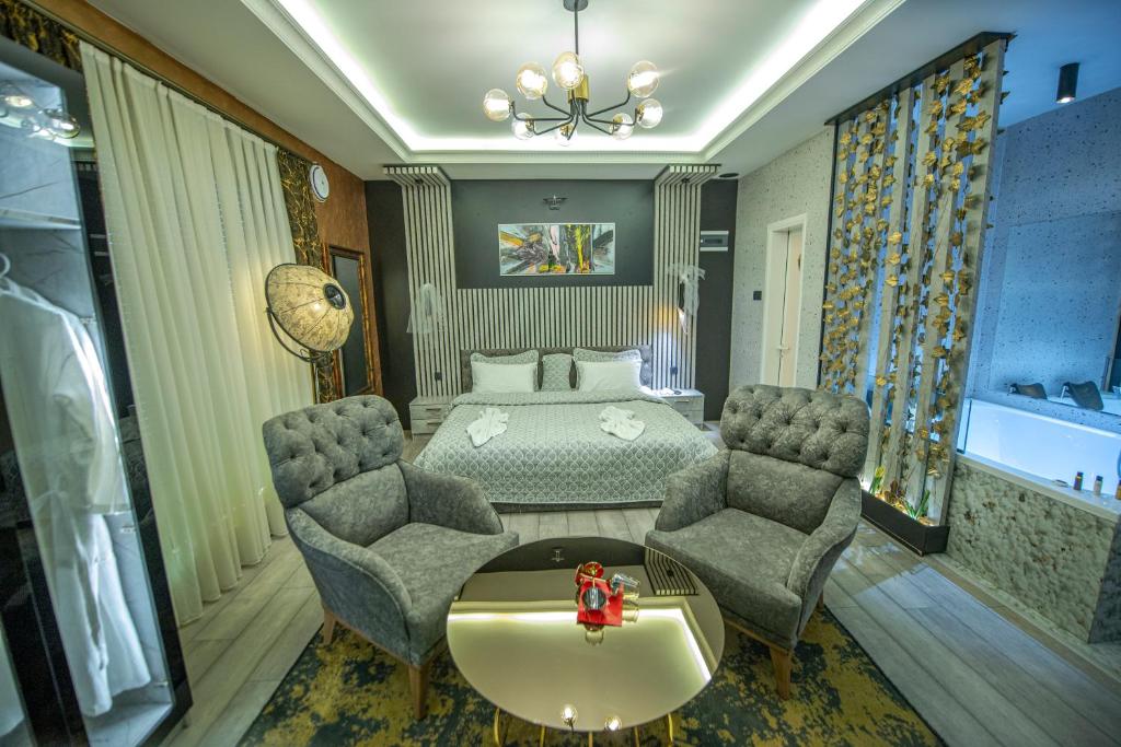 普里什蒂纳Hotel and Apartments Central City Prishtina的一间卧室配有一张床、两把椅子和一张桌子