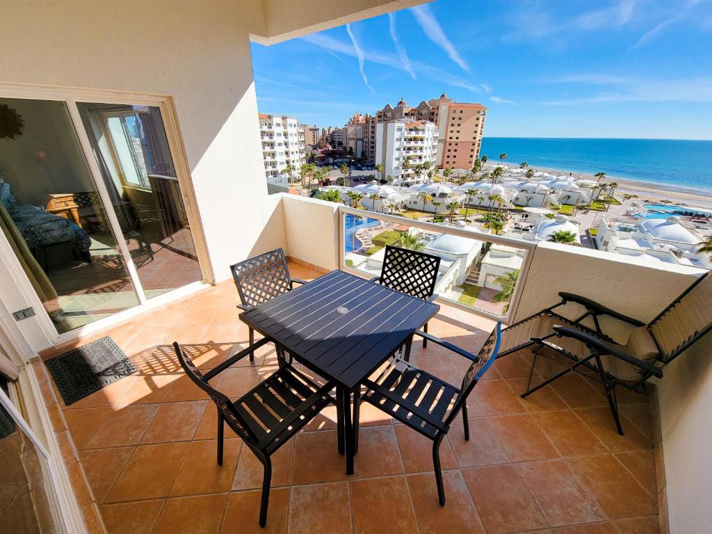 佩尼亚斯科港Las Palmas Resort Condo 603 with amazing sea view的海景阳台上的桌椅